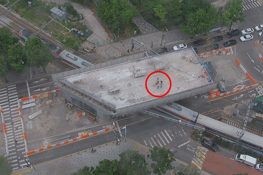 26日、崩落事故1分前にムグンファ号列車が車道下の線路を通過する中、工事関係者（赤い丸）が上部スラブ上に集まっている様子。死傷者6人は上部スラブと「ガーダー」（コンクリート製の梁）の間にいた。［写真 読者］