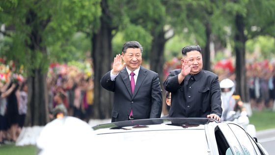  2019年6月20日、平壌を訪問した中国の習近平国家主席が北朝鮮の金正恩国務委員長とともにオープンカーに乗り歓迎する市民に手を振っている。［新華網 キャプチャー］