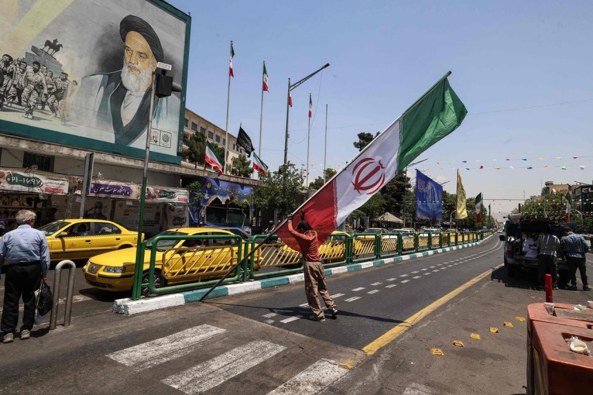 イランの首都テヘランのエンゲラブ広場で、イラン市民がイラン国旗を掲げている。イラン指導部は3日（現地時間）、米国がイランへの攻撃を再開した場合、さらに多くのミサイルおよびドローン攻撃があるだろうと警告した。AFP＝聯合ニュース