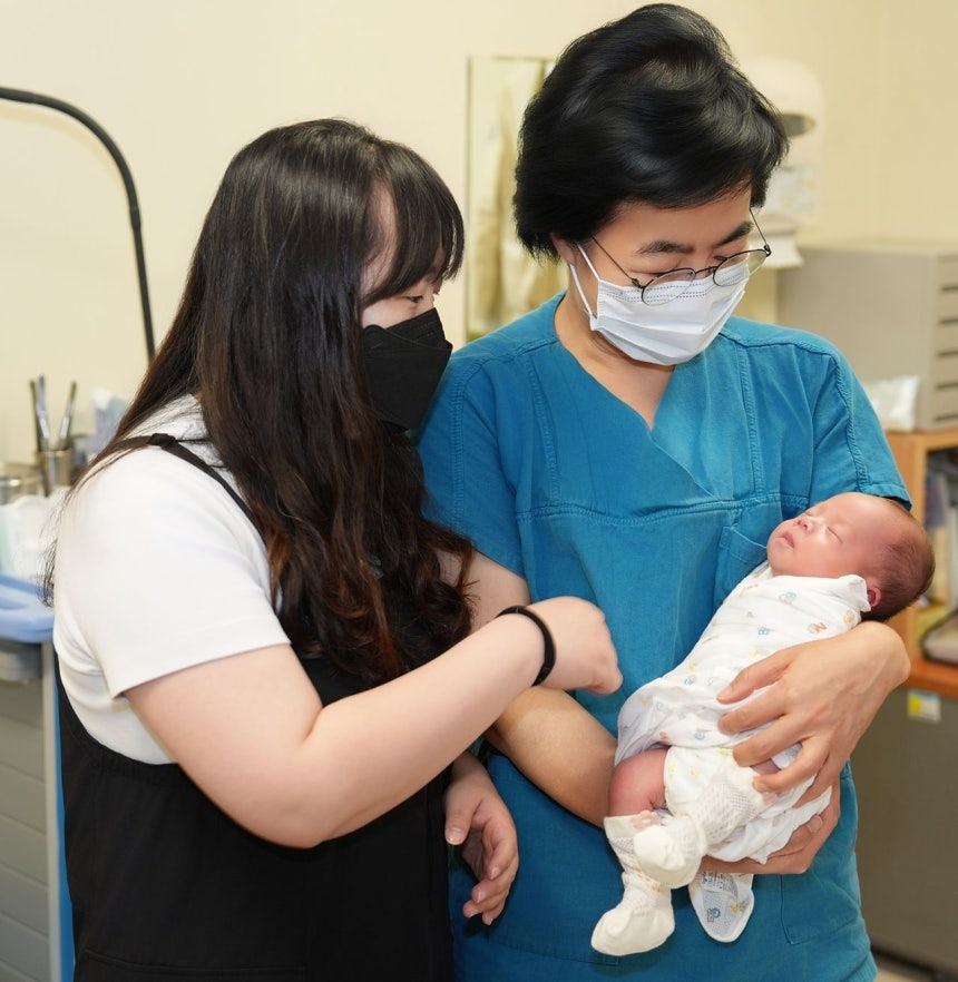 産婦（左）と主治医のコ・ヒョンソン教授が、元気に生まれてきた第2子を見守っている。［写真 ソウル聖母病院］
