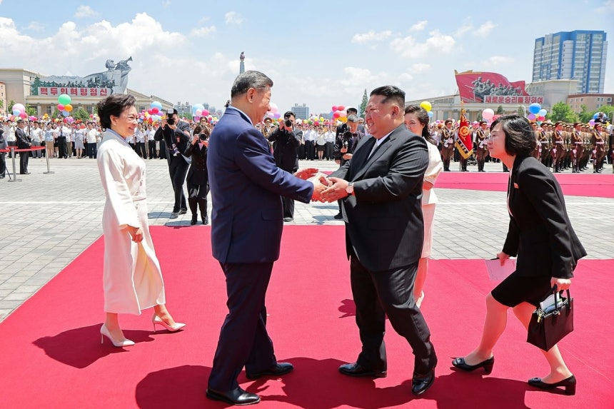 中国の習近平国家主席が8日に平壌を訪問し、空港に出迎えた北朝鮮の金正恩国務委員長と握手を交わしている。［写真 労働新聞＝ニュース1］