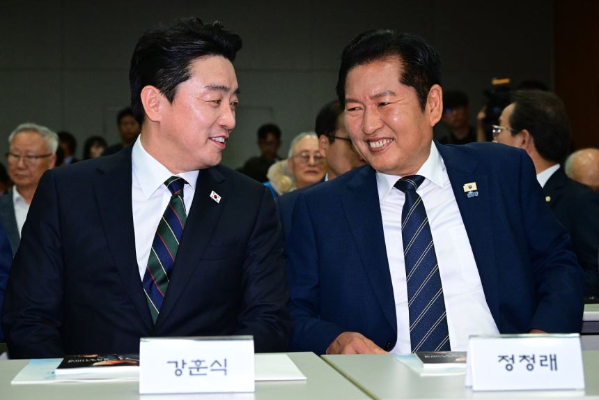 共に民主党の鄭清来（チョン・チョンレ）代表（右）と姜勲植（カン・フンシク）大統領秘書室長が15日、ソウル麻浦区の延世大学金大中（キム・デジュン）図書館コンベンションホールで開催された「6・15南北首脳会談26周年記念式および特別講演」で言葉を交わしている。［聯合ニュース］