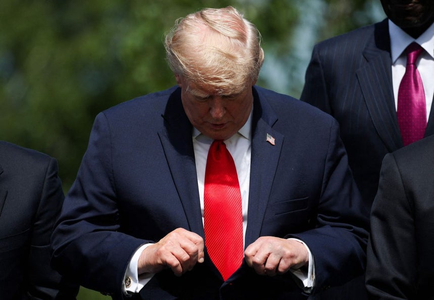 トランプ米大統領が16日、フランスのエビアンで開かれたG7首脳会議中の団体写真撮影に先立ちネクタイを結び直している。［写真 AFP＝聯合ニュース］