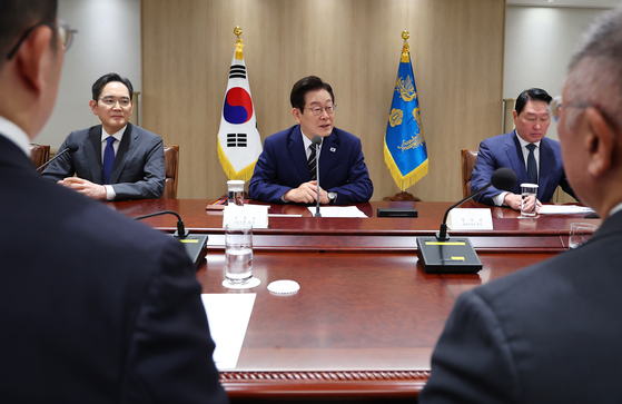 李在明大統領が昨年開かれた韓米関税交渉後続官民合同会議で発言している。中央から時計方向に李大統領、崔泰源SKグループ会長、鄭義宣現代自動車グループ会長、具光謨LGグループ会長、李在鎔サムスン電子会長。［写真 聯合ニュース］