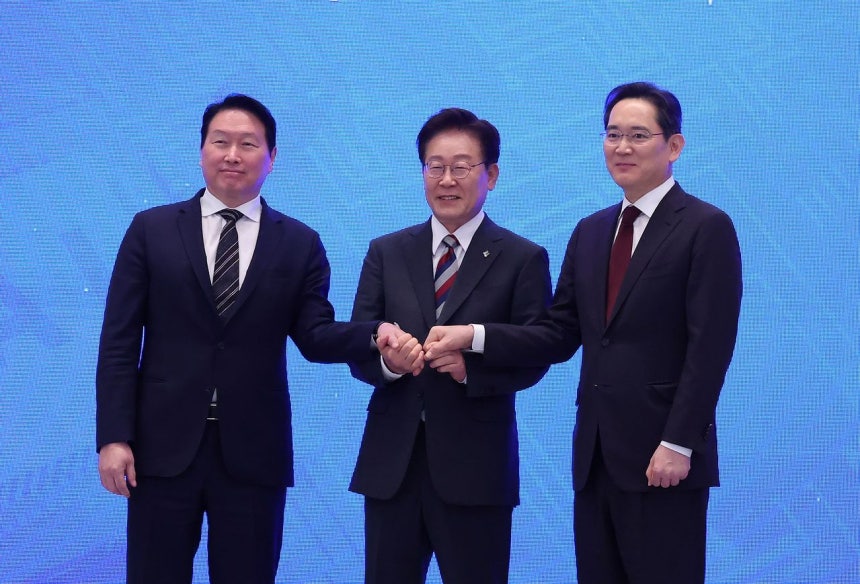李在明大統領とSKグループの崔泰源会長、サムスン電子の李在鎔会長が29日に開かれた「大韓民国大跳躍3大メガプロジェクト国民報告会」で手を取り合っている。［写真 青瓦台写真記者団］