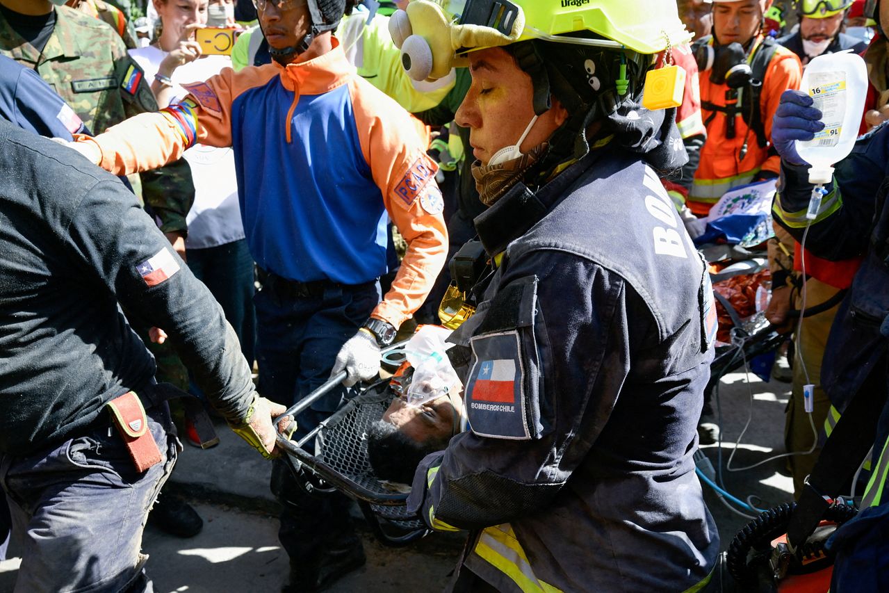 ベネズエラで大地震が発生してから8日間、建物のがれきの中で生き延びた男性を救助する救助隊員ら。［ロイター＝聯合ニュース］