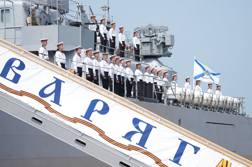 5日、ロシア太平洋艦隊所属のミサイル巡洋艦「ワリャーグ」が、中国との海上合同軍事演習「海上連合2026」に参加するため山東省青島港に入港し、乗組員が甲板上に整列している。タス＝聯合ニュース