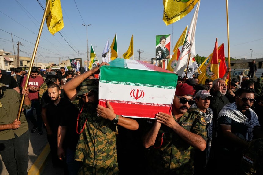29日、イラク・モスルで、米軍の空爆で死亡したイラン人軍事顧問の遺体が入った棺（ひつぎ）が運ばれている。AP＝聯合ニュース