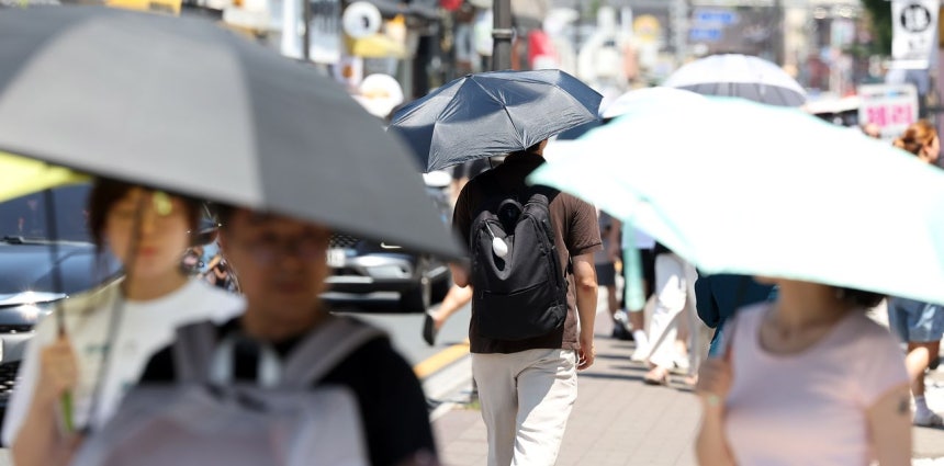 2日、慶尚北道慶州市（キョンサンブクド・キョンジュシ）に猛暑重大警報が発令される中、皇理団ギル（ファンニダンギル）を観光客が日傘を差して歩いている。［聯合ニュース］
