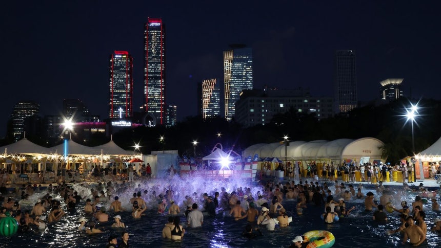 夜の気温が30度を上回る熱帯夜が続いた6日夜、ソウル・永登浦区（ヨンドゥンポグ）の汝矣島（ヨイド）漢江（ハンガン）プールで、市民らが水遊びをしながら暑さをしのいでいる。［ニュース1］