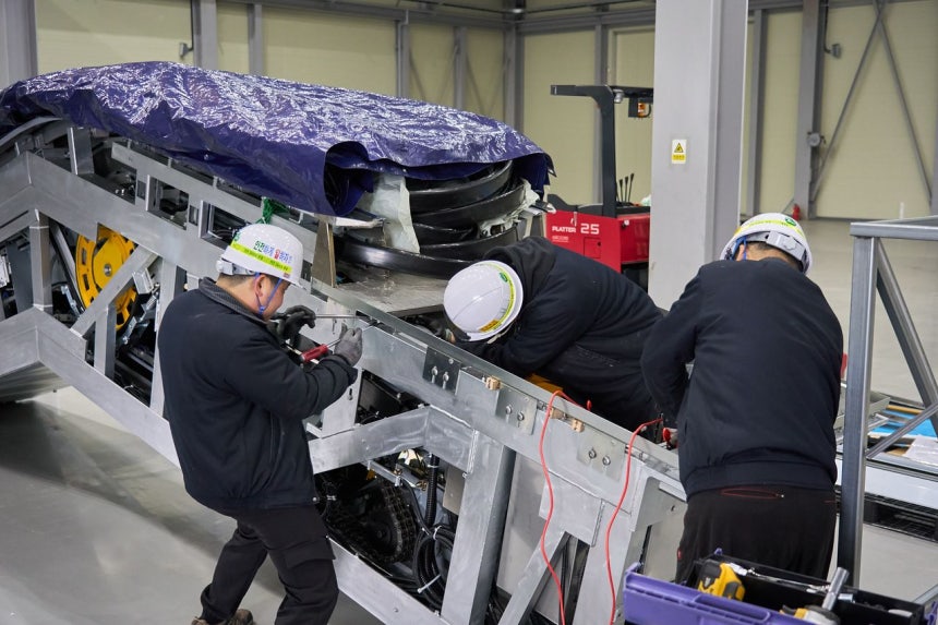 Kエスカレーター職員が製品を組み立てている。エスカレーターは建物の高さや設置位置により形が異なるためすべての製品が個別に製作される。 ［写真 Kエスカレーター］