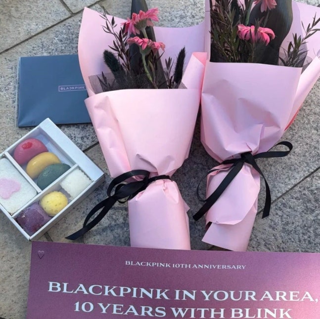   BLACKPINK（ブラックピンク）の10周年記念ファンイベントで贈られた花束と餅。［SNS キャプチャー］