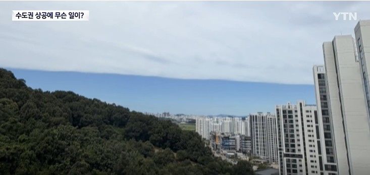 水平に線を引いたように白と青に分かれた空。［写真 YTNニュース画面キャプチャー］