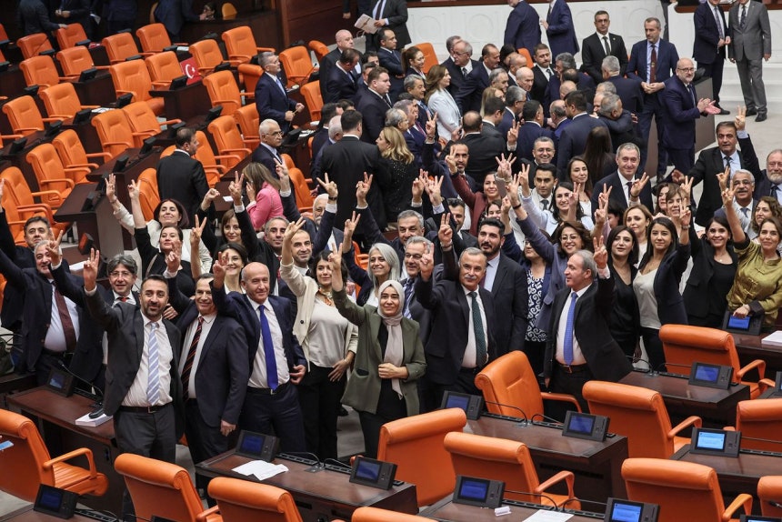 10日、トルコ議会で親クルド性向の人民平等民主党（DEM）議員がクルド労働者党（PKK）の武装解除と犯罪容疑処罰を猶予する法案が通過すると勝利を意味するVサインを出している。［写真 AFP＝聯合ニュース］