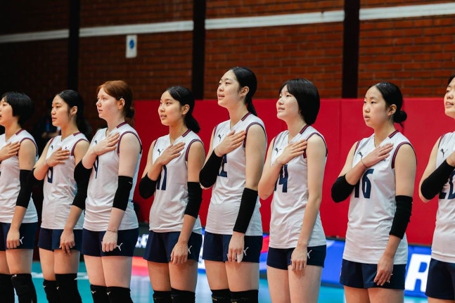 韓国選手がアルジェリア戦の前の愛国歌（国歌）演奏で国旗に敬礼している。 ［写真 FIVB］