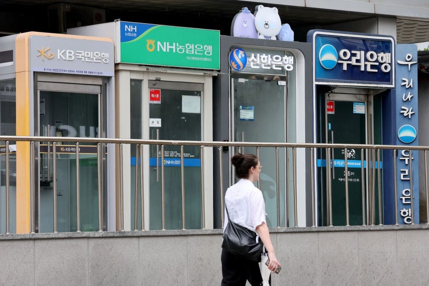 ソウル市竜山区（ヨンサング）の市中銀行のATMの前を女性が通り過ぎている。ニュース1