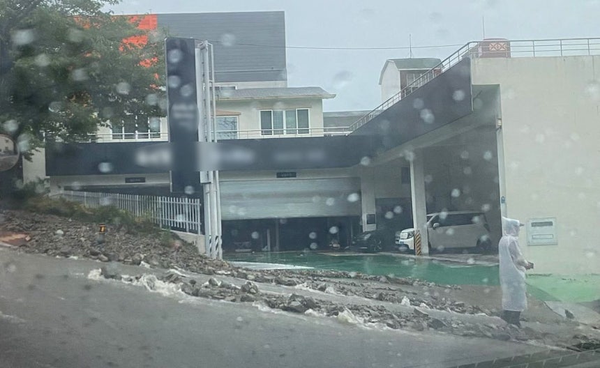   豪雨で流れ落ち、道路上に堆積した土砂と石。聯合ニュース