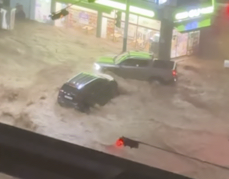 巨済（コジェ）市内で激しい水流に流される車。［SNS キャプチャー］