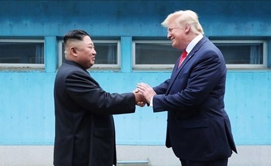 北朝鮮の金正恩（キム・ジョンウン）国務委員長（左）と米国のドナルド・トランプ大統領が2019年6月30日、板門店（パンムンジョム）で会い、握手を交わしている。［写真 朝鮮中央通信ホームページ］