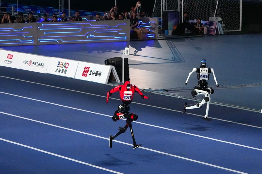 22日に北京で開かれた第2回ワールドヒューマノイドロボットゲームの100メートル走で右側の白いロボットが9秒39を記録した。［写真 新華社＝聯合ニュース］