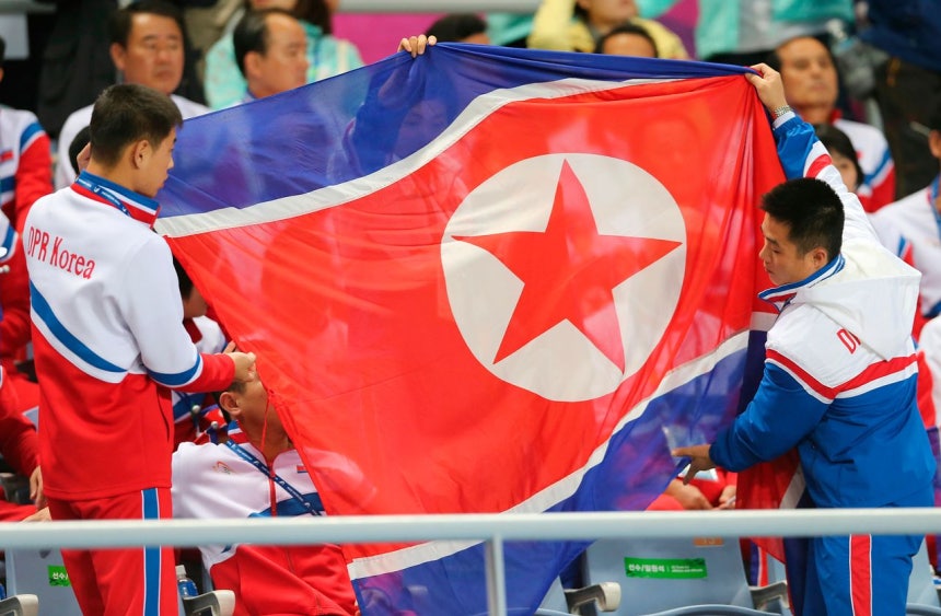 2014年10月1日、仁川で開かれたアジア大会の女子サッカー決勝戦で北朝鮮選手団が北朝鮮国旗を広げるため準備している。［写真 AP＝聯合ニュース］