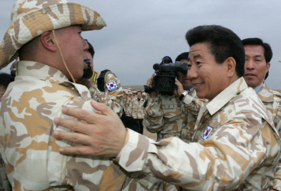 2004年12月、韓国の盧武鉉（ノ・ムヒョン）大統領（右）が、イラクのザイトゥーン部隊を訪問して将兵を激励している。青瓦台写真記者団