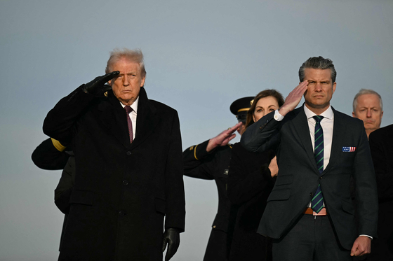 米軍遺体返還式で敬礼しているトランプ大統領とヘグセス国防長官。AFP＝聯合ニュース
