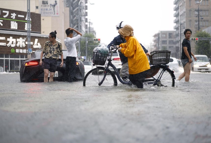 8日（現地時間）、名古屋で豪雨により冠水した道路を歩く人々。［共同通信・ロイター＝聯合ニュース］