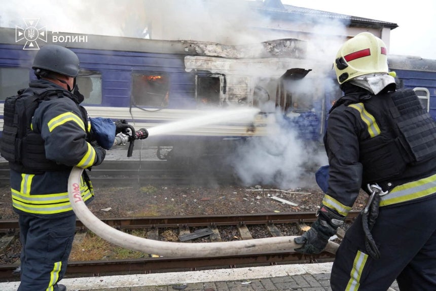 12日（現地時間）、ウクライナのルツクの鉄道駅で、消防隊員がロシアのドローン攻撃を受けた旅客列車の火を消している。［ロイター＝聯合ニュース］