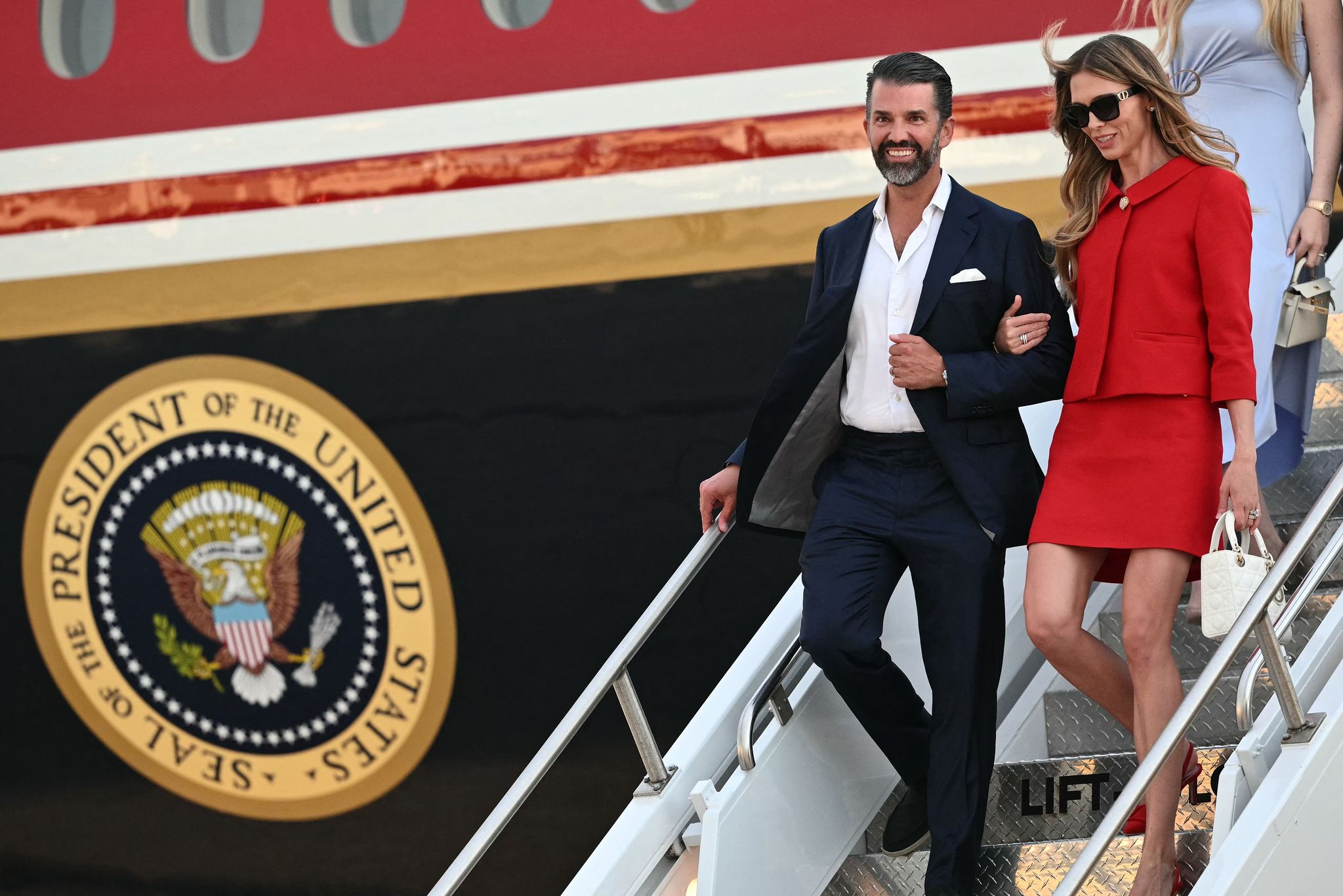 エアフォースワンから降りるドナルド・トランプ・ジュニア氏と妻ベッティーナ・アンダーソンさん。AFP＝聯合ニュース