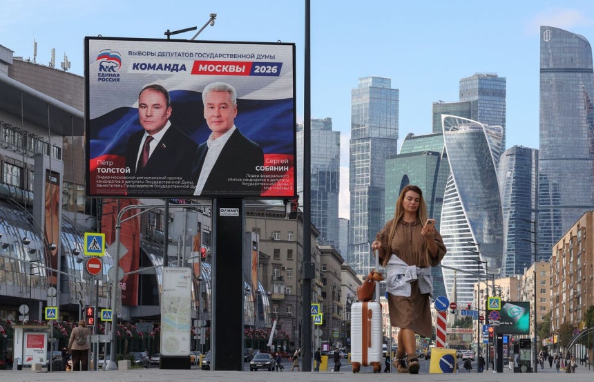 15日、モスクワ国際ビジネスセンター近くである女性が統一ロシアの選挙広報の前を通り過ぎている。［写真 ロイター＝聯合ニュース］