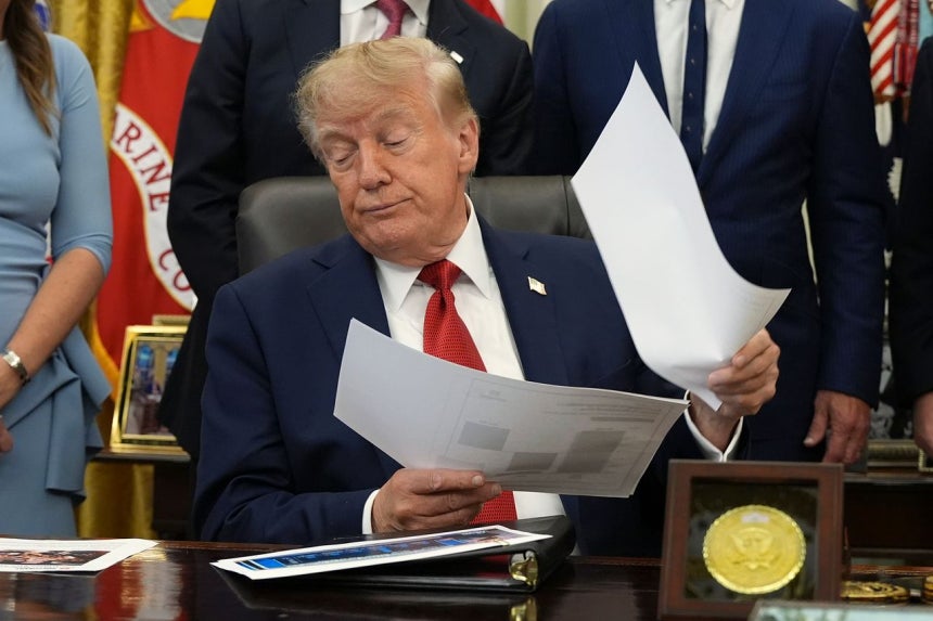 トランプ米国大統領が18日、ホワイトハウスで医療問題と関連した発言中に関連書類を確認している。［写真 AP＝聯合ニュース］