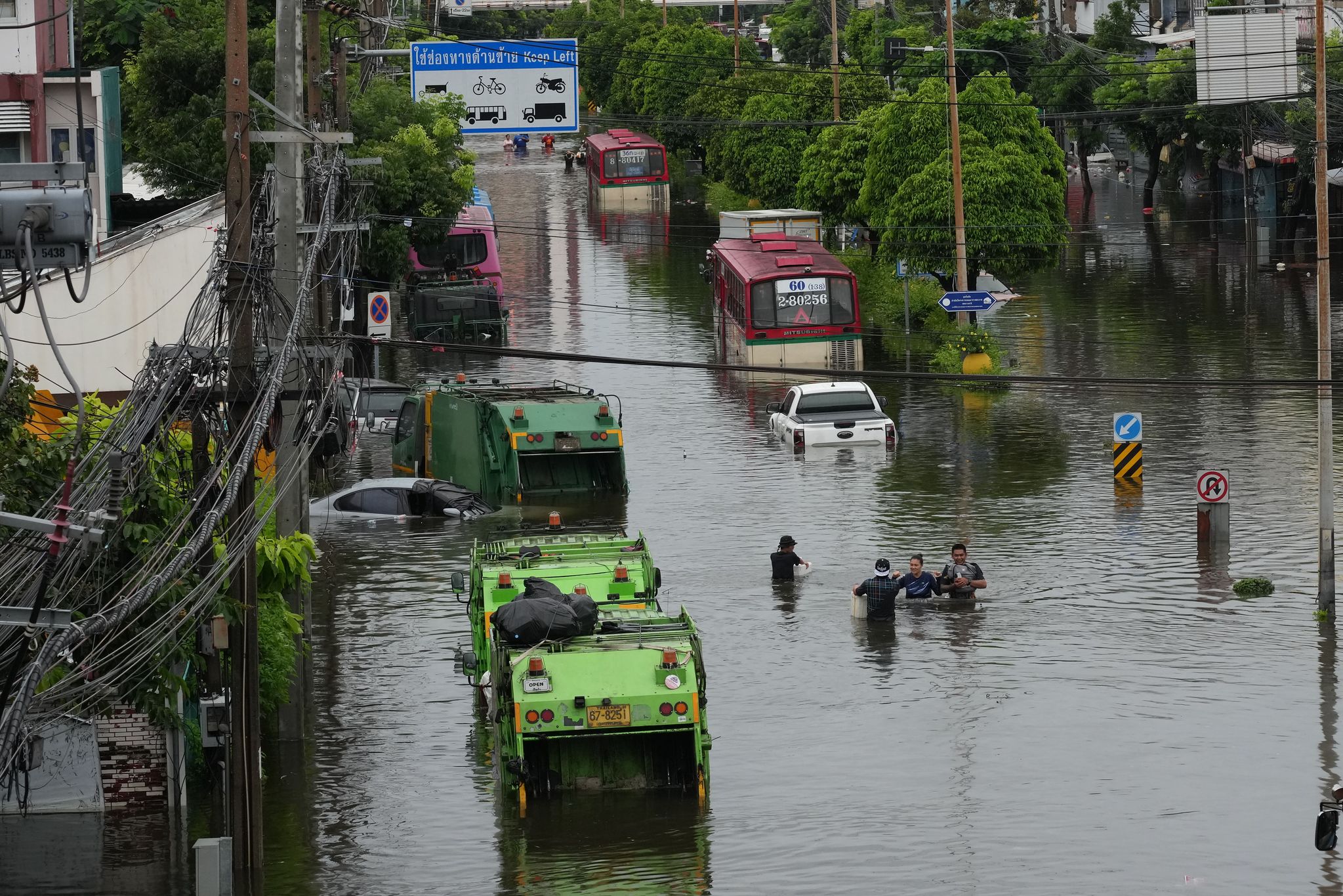  タイ・バンコクで豪雨が降った後、市民が冠水した道路を通っている。AP＝聯合ニュース