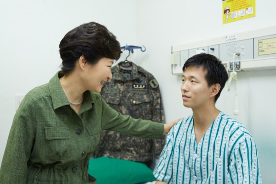 2015年8月6日、当時の朴槿恵（パク・クネ）大統領が国軍首都病院を訪問し、DMZ地雷挑発により負傷したキム・ジョンウォン下士官を励ましている。［写真 青瓦台提供］