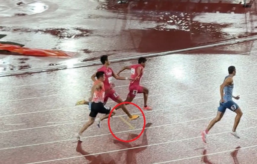  競技中、中国選手がバトンタッチゾーンを越えてバトンを受け渡す場面。［写真 中継放送 キャプチャー］