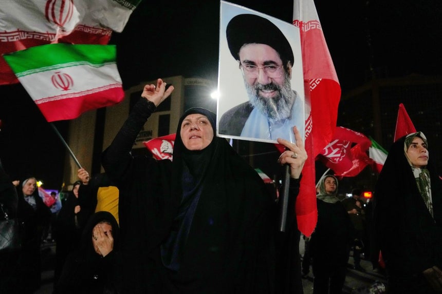9日、イランのテヘランで開かれた親政府デモで、女性がイランの最高指導者モジタバ・ハメネイ師の写真を掲げている。［AP＝聯合ニュース］