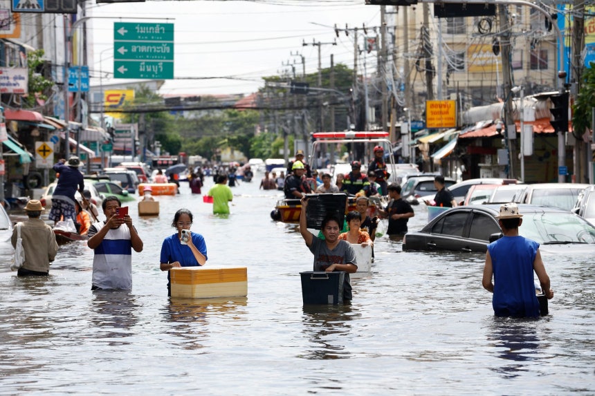 先月29日（現地時間）、タイ・バンコクのラートクラバン地区にある公営住宅団地で、住民が食料や生活必需品を手に入れるため浸水した道路を通行している。［EPA＝聯合ニュース］