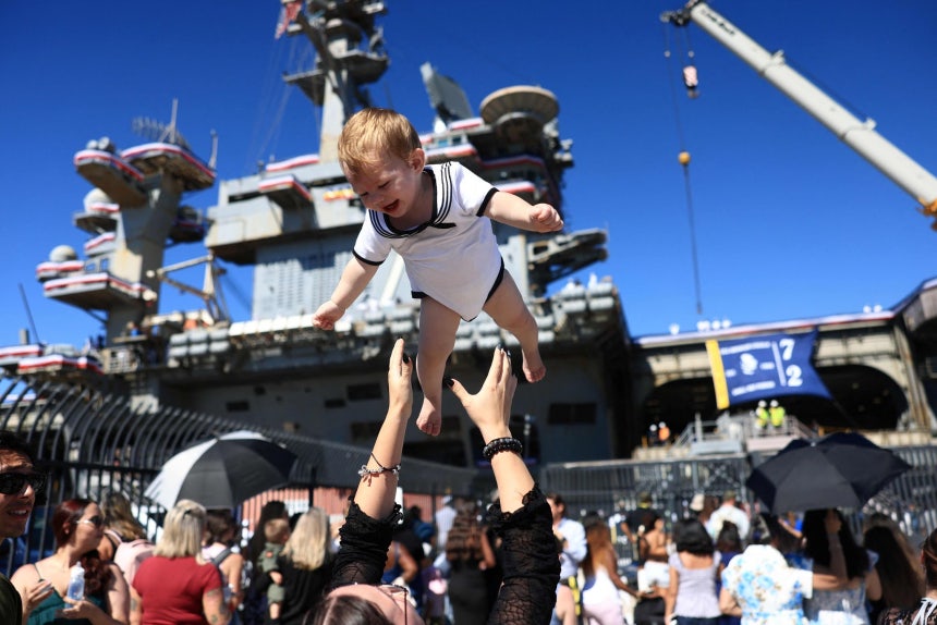8日（現地時間）、米カリフォルニア州サンディエゴのノースアイランド海軍航空基地に米海軍の空母「エイブラハム・リンカーン」（CVN－72）が入港し、乗組員の家族が喜んでいる。［AFP＝聯合ニュース］