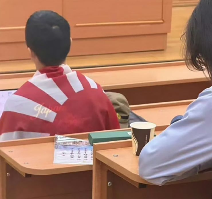 モスクワ大学でロシア語の授業中に旭日旗を身にまとった中国人留学生。［SNS キャプチャー］