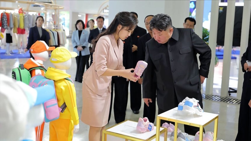 北朝鮮の金正恩国務委員長が19日、「全国被服・靴展示会2026」を訪れ、娘のジュエ氏が手にするピンク色の児童用運動靴を見ている。［写真 朝鮮中央テレビ画面＝聯合ニュース］
