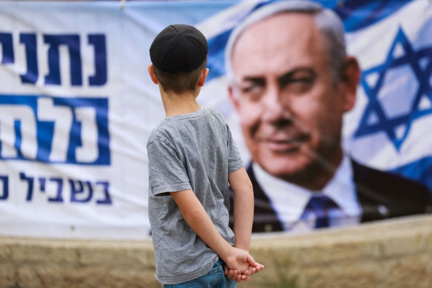 27日、イスラエルの総選挙期間中に子どもがイスラエルのネタニヤフ首相が写る垂れ幕を眺めている。［写真 ロイター＝聯合ニュース］